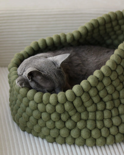 Cozy basket-style cat bed made from handmade New Zealand wool featuring a peek-out design for playful cats. 4
