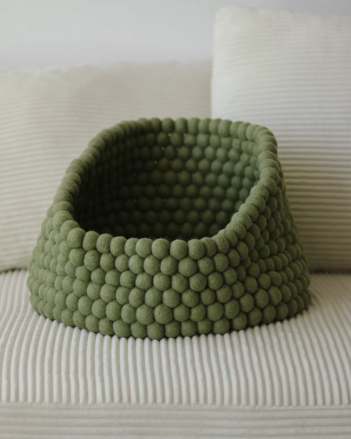 Cozy basket-style cat bed made from handmade New Zealand wool featuring a peek-out design for playful cats. 5